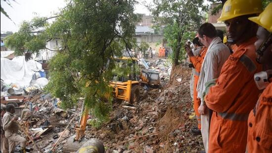 Rescue teams and local officials clear debris at southeast Delhi’s Jaitpur, where a wall collapse killed seven on Saturday morning. (HT Photo)
