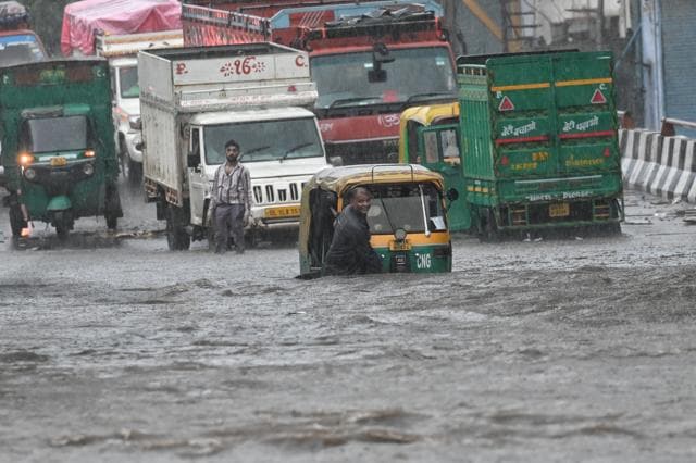 Commuters wade through a waterlogged stretch over Rohtak Road near Anand Parbat on Saturday. (Sanchit Khanna/HT) Commuters wade through a waterlogged stretch over Rohtak Road near Anand Parbat on Saturday. (Sanchit Khanna/HT)