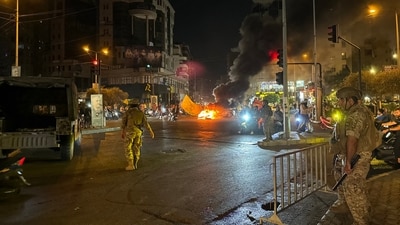 Lebanese soldiers look on as supporters of the Hezbollah militant group block the streets with burning tires while rallying in cars and motorbikes to protest the government's endorsement of a plan to disarm it, in Beirut's southern suburbs early on August 8, 2025. (AFP) Lebanese soldiers look on as supporters of the Hezbollah militant group block the streets with burning tires while rallying in cars and motorbikes to protest the government's endorsement of a plan to disarm it, in Beirut's southern suburbs early on August 8, 2025. (AFP)