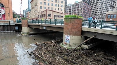 People watch as debris piles up on a bridge piling on the Milwaukee River after heavy rain in the area on August 10, 2025 in Milwaukee, Wisconsin. (Getty Images via AFP) People watch as debris piles up on a bridge piling on the Milwaukee River after heavy rain in the area on August 10, 2025 in Milwaukee, Wisconsin. (Getty Images via AFP)