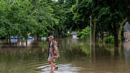 A person walks in floodwaters on August 10, 2025 in Wauwatosa, Wisconsin. Parts of Interstates 43, 41, and 94 have been forced to close due to flash floods. Additionally closed are portions of Wisconsin 175 North at I-94 and Brewers Boulevard.(Getty Images via AFP)