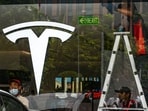 Workers prepare for the opening of the new Tesla store in New Delhi.