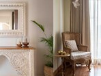 A hand-carved wooden mantle with a mirror above adds heritage charm while blending effortlessly into a sleek, modern living space.