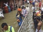 People wade through a waterlogged street near Kashi Vishwanath temple in Varanasi earlier this month. (PTI)