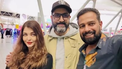 Aishwarya Rai and Abhishek Bachchan posing with a fan at the airport. Aishwarya Rai and Abhishek Bachchan posing with a fan at the airport.