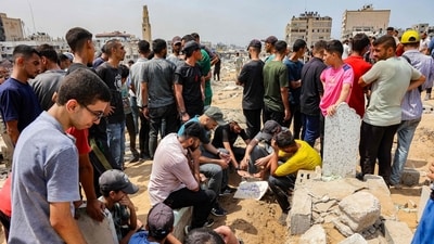 Mourners sit around the grave of Al Jazeera correspondent Anas al-Sharif, who was killed alongside other journalists in an overnight Israeli strike on their tent in Gaza City, following his burial at the Sheikh Radwan cemetery in Gaza City on August 11, 2025. (Omar Al Qattaa/AFP) Mourners sit around the grave of Al Jazeera correspondent Anas al-Sharif, who was killed alongside other journalists in an overnight Israeli strike on their tent in Gaza City, following his burial at the Sheikh Radwan cemetery in Gaza City on August 11, 2025. (Omar Al Qattaa/AFP)