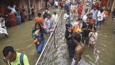 People wade through a waterlogged street near Kashi Vishwanath temple in Varanasi earlier this month. (PTI) People wade through a waterlogged street near Kashi Vishwanath temple in Varanasi earlier this month. (PTI)
