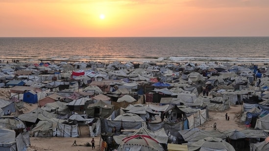 Tents housing displaced Palestinians crowd the beach in Gaza City, as the sun sets over the Mediterranean Sea.(Jehad Alshrafi/AP)