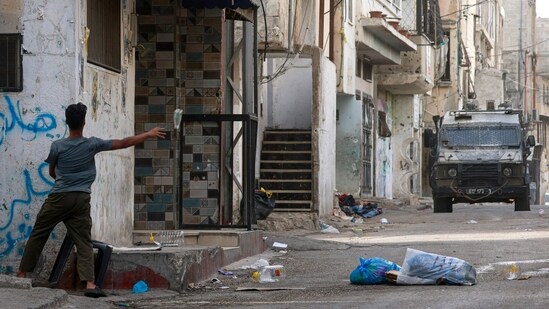 A Palestinian man throws a bottle at Israeli soldiers during a raid at the Balata refugee camp east of Nablus city in the occupied West Bank on August 11, 2025. Violence in the West Bank, which Israel has occupied since 1967, has surged throughout the Gaza war that began in October 2023. At least 968 Palestinians, including militants but also civilians, have been killed by Israeli soldiers or settlers since the Gaza war broke out.(Jaafar Ashtiyeh/AFP)