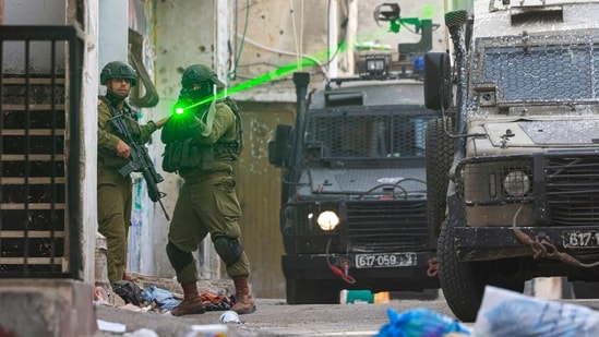 An Israeli soldier aims his weapon during a raid at the Balata refugee camp east of Nablus city in the occupied West Bank on August 11, 2025.(Jaafar Ashtiyeh/AFP)