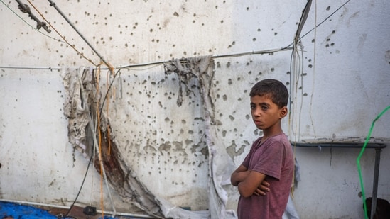 A Palestinian boy stands beside the destroyed Al Jazeera tent at Al-Shifa Hospital in Gaza City on August 11, 2025, following an overnight strike by the Israeli military.(Bashar Taleb/AFP)