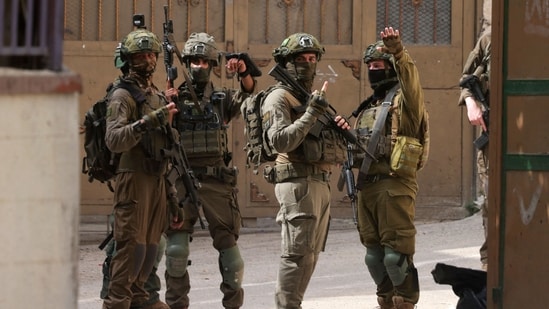 Israeli soldiers gesture during a raid at the Balata refugee camp east of Nablus city in the occupied West Bank on August 11, 2025.(Jaafar Ashtiyeh/AFP)