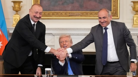 President Donald Trump, center, shakes hands with Armenian Prime Minister Nikol Pashinyan, right, and Azerbaijan President Ilham Aliyev during a trilateral signing ceremony in the State Dining Room of the White House (AP)