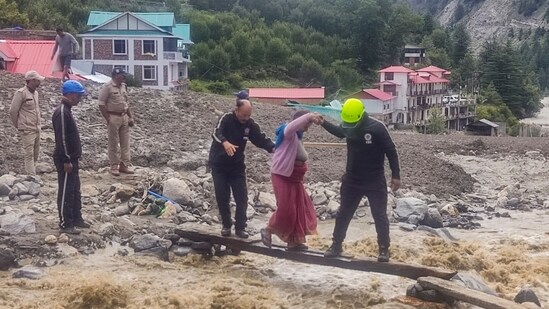 Fire and police personnel were seen evacuating villagers at the disaster-hit Dharali area, in the aftermath of the recent flash floods.(@uttarakhandcop/X)