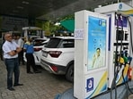 A man reads a notice announcing the ban on refuelling petrol cars older than 15 years and diesel vehicles older than 10 years, displayed at a gas station in New Delhi.