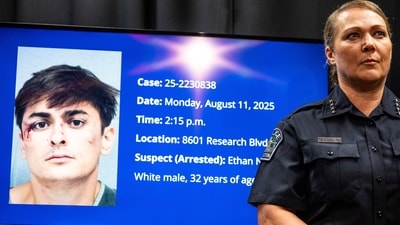Austin Police Chief Lisa Davis stands by as a photo of and information about shooting suspect Ethan Nieneker, 35, are displayed (AP) Austin Police Chief Lisa Davis stands by as a photo of and information about shooting suspect Ethan Nieneker, 35, are displayed (AP)