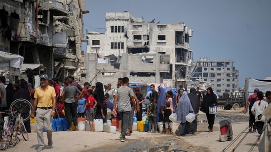 In the summer heat, Palestinians line up to collect water from a distribution point in Gaza City, Tuesday, Aug. 12, 2025. (AP)