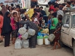 Palestinians queue to fill up on drinking water in the sweltering heat in the Mawasi area of Khan Yunis in the southern Gaza Strip on August 12, 2025.