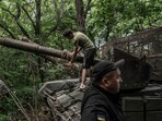 A tank crew from the 68th Jaeger Brigade performs maintenance work hidden in a line of trees in Ukraine’s Donetsk region.
