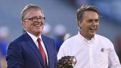 David Booth, left, receives a proclamation from then-Kansas Gov. Jeff Colyer, M.D., during halftime of a Kansas NCAA college football game in Lawrence, Kan., Sept. 1, 2018. (AP Photo/Reed Hoffmann, file) (AP) David Booth, left, receives a proclamation from then-Kansas Gov. Jeff Colyer, M.D., during halftime of a Kansas NCAA college football game in Lawrence, Kan., Sept. 1, 2018. (AP Photo/Reed Hoffmann, file) (AP)