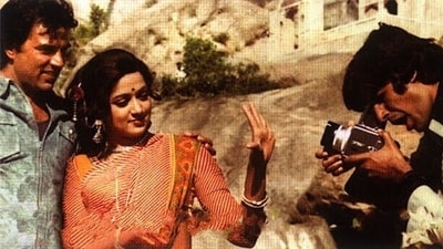 One candid moment from the shooting of Sholay shows Dharmendra and Hema Malini, who were yet to be married, posing for a picture clicked by Amitabh Bachchan. One candid moment from the shooting of Sholay shows Dharmendra and Hema Malini, who were yet to be married, posing for a picture clicked by Amitabh Bachchan. 