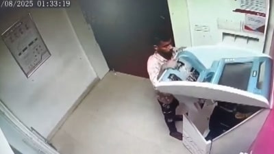 The CCTV visual show the man standing in front of an open Automated Teller Machine (ATM), placing back black device inside it before two people come and overpower him (X/PTI) The CCTV visual show the man standing in front of an open Automated Teller Machine (ATM), placing back black device inside it before two people come and overpower him (X/PTI)
