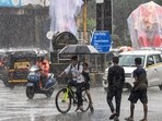 Commuters using umbrellas during rain in Mumbai, Maharashtra