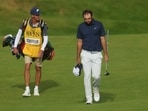 Scottie Scheffler and his caddie, Ted Scott walk up the 18th hole before winning the 153rd Open Championship 
