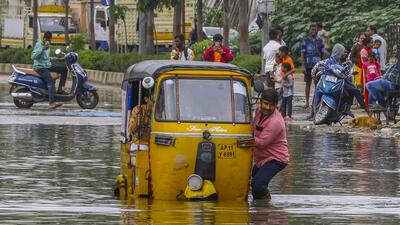 An auto-rickshaw driver pulls his vehicle through a waterlogged road, after eight gates of Himayat Sagar reservoir were opened, in Hyderabad, on Thursday (PTI) An auto-rickshaw driver pulls his vehicle through a waterlogged road, after eight gates of Himayat Sagar reservoir were opened, in Hyderabad, on Thursday (PTI)