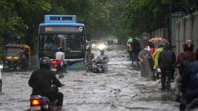 A DTC bus is seen to make its way through a waterlogged street in New Delhi on August 14, after intense downpours braced the capital city. (Salman Ali/PTI)