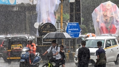 An idol of Lord Ganesha, clad in a plastic sheet to keep the rainwater away makes its way through Mumbai as heavy rain drenches the city ahead of its biggest festival. (PTI)