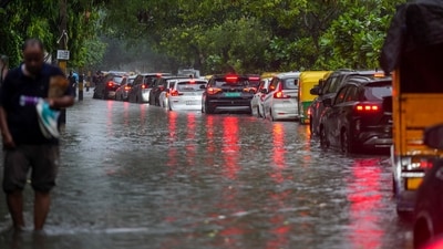 Several vehicles are seen to be stalled in a waterlogged road in Delhi as heavy rainfall continues to lash the city today. (PTI)