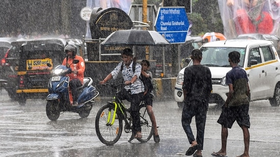 Commuters using umbrellas during rain in Mumbai, Maharashtra (PTI)