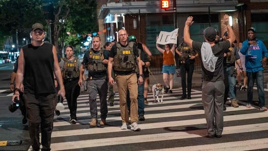 FBI agents are followed by protesters in the U street neighborhood on August 13, 2025 in Washington, DC. U.S. (Photo by Andrew Leyden / GETTY IMAGES NORTH AMERICA / Getty Images via AFP) (Getty Images via AFP)