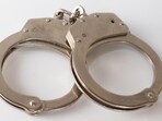 A high angle shot of metal handcuffs isolated on a white background A high angle shot of metal handcuffs isolated on a white background