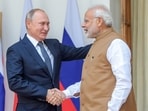 Prime Minister Narendra Modi shakes hands with Russian President Vladimir Putin.