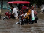 Motorists ride through a flooded road caused by heavy monsoon rain in Lahore, Pakistan.