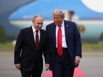 President Donald Trump (R) walks with Russian President Vladimir Putin as they arrive at Joint Base Elmendorf-Richardson 