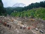 Stranded pilgrims are helped across a water channel using a makeshift bridge a day after flash floods in Chishoti village, Kishtwar district. (AP)