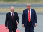 Russian President Vladimir Putin and US President Donald Trump walk on the tarmac 