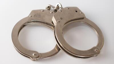 A high angle shot of metal handcuffs isolated on a white background