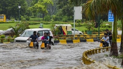 Commuters wade through a waterlogged road after rainfall near AIIMS in New Delhi on Thursday. (PTI) Commuters wade through a waterlogged road after rainfall near AIIMS in New Delhi on Thursday. (PTI)