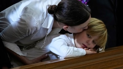 Maria Claudia Tarazona comforts her son Alejandro during the funeral service for her husband, presidential hopeful and opposition Sen. Miguel Uribe, who died from wounds sustained when he was shot at a political rally, in Bogota, Colombia, Aug. 13 (AP) Maria Claudia Tarazona comforts her son Alejandro during the funeral service for her husband, presidential hopeful and opposition Sen. Miguel Uribe, who died from wounds sustained when he was shot at a political rally, in Bogota, Colombia, Aug. 13 (AP)