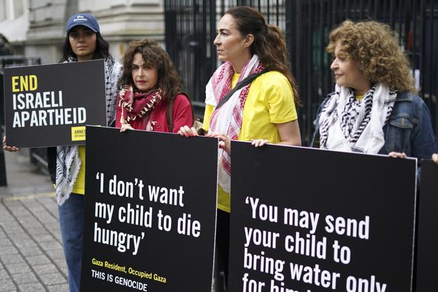 From left to right, Aiysha Hart, Selma Dabbagh, Esther Manito, Nadia Sawalha, hold placards during a demonstration in support of the Palestinian people in Gaza, outside the gates of Downing Street, in London, Wednesday, May 21, 2025. (AP)