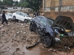 Local residents look damaged cars trapped in a mud following flash flooding due to heavy rains at a neighbourhood of Mingora, the main town of Swat Valley, northwestern Pakistan.