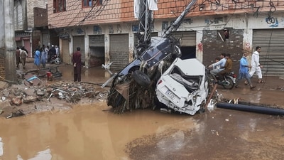 Residents walk next to damaged cars stuck to an electric pole following flash flooding due to heavy rains in a neighborhood of Mingora, the main town of Swat Valley, northwestern Pakistan, Friday, Aug. 15, 2025. (AP) Residents walk next to damaged cars stuck to an electric pole following flash flooding due to heavy rains in a neighborhood of Mingora, the main town of Swat Valley, northwestern Pakistan, Friday, Aug. 15, 2025. (AP)