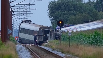 Police officers inspect the passenger train derailed in an accident on its way to Soenderborg at the village of Bjerndrup between Kliplev and Tinglev is pictured in south-western Denmark. (AFP) Police officers inspect the passenger train derailed in an accident on its way to Soenderborg at the village of Bjerndrup between Kliplev and Tinglev is pictured in south-western Denmark. (AFP)