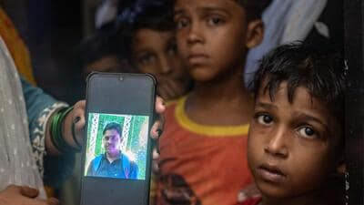 Mumbai, India - August 16, 2025: Family members and the two sons of Jagmohan Shivkiram Chaudgari hold up his photograph in grief. Jagmohan tragically lost his life while tying the Dahi Handi rope during festival preparations at Mankhurd in Mumbai, India, on Saturday, August 16, 2025. (Photo by Satish Bate/ Hindustan Times) (Hindustan Times) Mumbai, India - August 16, 2025: Family members and the two sons of Jagmohan Shivkiram Chaudgari hold up his photograph in grief. Jagmohan tragically lost his life while tying the Dahi Handi rope during festival preparations at Mankhurd in Mumbai, India, on Saturday, August 16, 2025. (Photo by Satish Bate/ Hindustan Times) (Hindustan Times)
