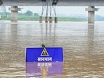 A warning signboard in the Yamuna River near Vasudev Ghat in New Delhi as water levels increase.