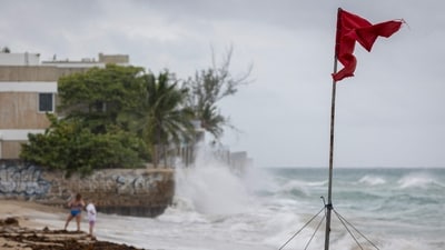 A ripped red flag warning of rip current waves as Category 5 Hurricane Erin approaches in San Juan, Puerto Rico, on August 16, 2025.&nbsp; (AFP)